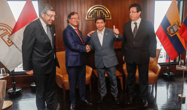 El presidente sonríe para la foto junto a Petro y otros dos funcionarios. Atrás, se aprecia la bandera también de la CAN y de Colombia