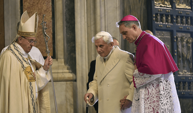 El Papa Emérito Benedicto XVI es ayudado por su secretario, Georg Gaenswein, durante una ceremonia religiosa de 2015.