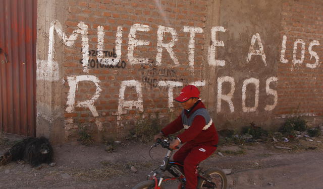 Un niño juega inocentemente donde al llegar la noche se convierte en tierra de nadie y se lle en sus paredes "Muerte a los rateros". Foto: Juan Carlos Cisneros/La República