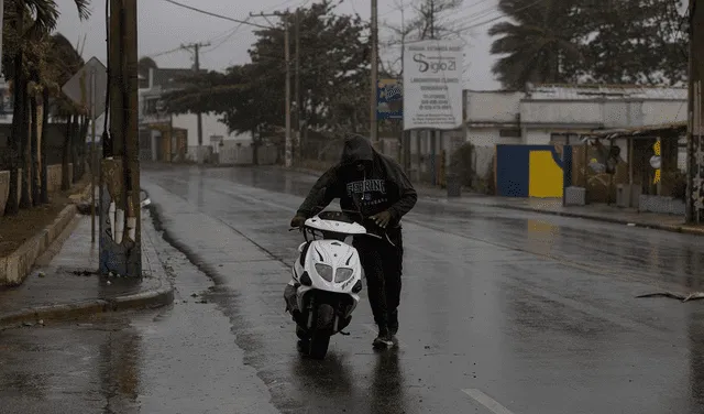 Un hombre empuja su motocicleta en busca de combustible, hoy en Nagua (República Dominicana).