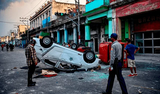 Autos de la Policía cubana que fueron volcados por los manifestantes en una calle de La Habana. Foto: AFP