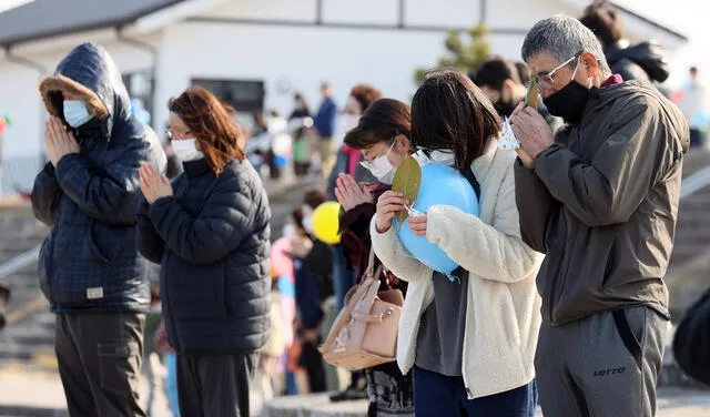 People observe a moment of silent prayers for the victims of the devastating 2011. Foto: EFE