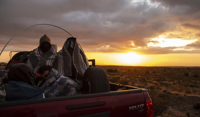 Rubi Alexander G. (d) y sus amigos viajan en un automóvil de Bolivia a Chile. Foto: AFP