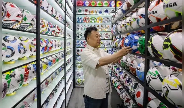 Un vendedor chino revisa un balón de fútbol en el Mercado Internacional de Comercio de Yiwu