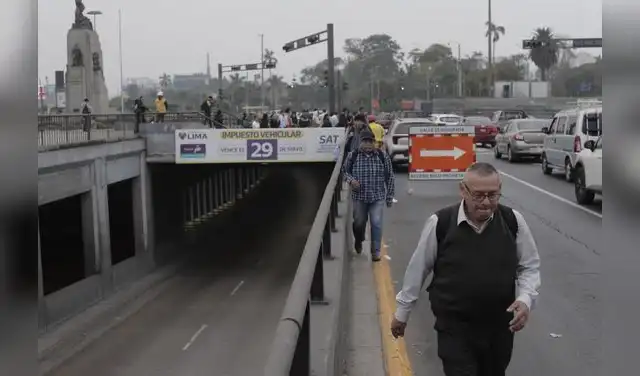 Pasajeros movilizándose a pie por el borde de la vía debido a la congestión