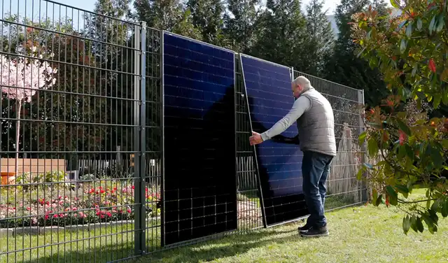 Un usuario instala una cerca equipada de paneles solares. Foto: Green Aku