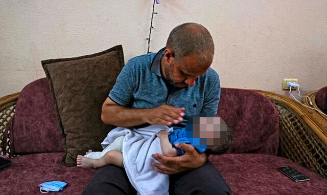 Padre se aferra a su bebé tras perder a su familia por bombardeo israelí