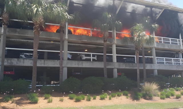  Firefighters worked to extinguish flames engulfing the Jacksonville International Airport parking garage. Photo: Yahoo News   