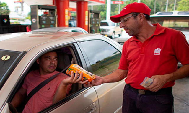 Orlando Godoy, empleado de una gasolinera en Caracas, recibe un paquete de harina de maíz el 8 de octubre
