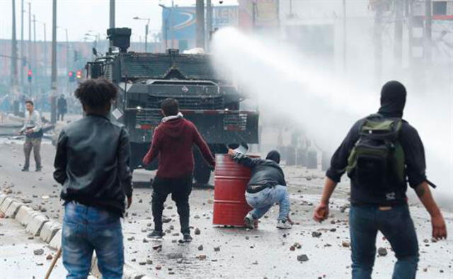 Una tanqueta de la policía antidisturbios en enfrentamiento con un grupo de manifestantes el viernes en Bogotá