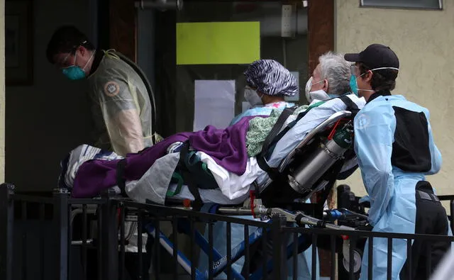 Técnicos médicos de emergencia trasladan a un paciente afectado por Covid-19 en una camilla de una ambulancia al Centro de Atención y Rehabilitación Gateway el 16 de abril de 2020 en Hayward, California.