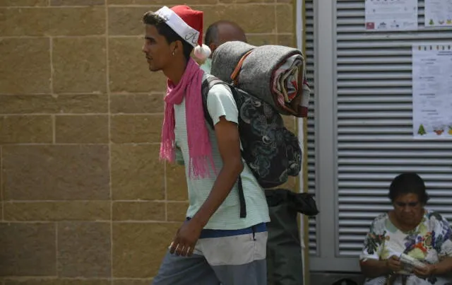 A Venezuelan migrant carrying a backpack walks in Bucaramanga, Colombia, on December 17, 2019. - Venezuelan migrants in Colombia undertake a round trip to their country with the desire to spend Christmas at home. (Photo by Juan BARRETO / AFP)