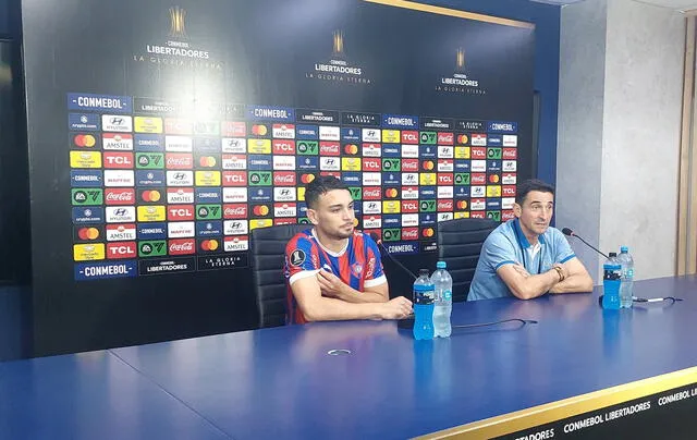 Manolo Jiménez junto con uno de sus jugadores en conferencia de prensa. Foto: X (antes Twitter).   