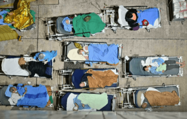 Personas duermen en camas instaladas afuera del hospital Caritas Medical Centre de Hong Kong, el 16 de febrero de 2022.