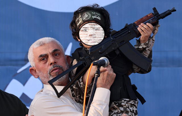 El líder de Hamás, Yahya Sinwar, sostiene al hijo de un combatiente de las Brigadas Al-Qassam, que murió en enfrentamientos con Israel. Foto: AFP 