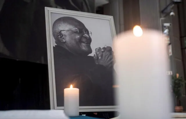 Velas encendidas han sido colocadas delante de una fotografía del difunto arzobispo emérito Desmond Tutu. Foto: EFE