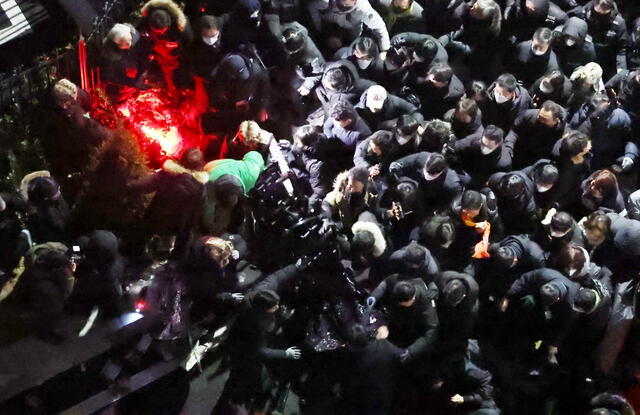 Funcionarios de la CIO y agentes de policía rompen las barricadas para entrar en la residencia presidencial de Seúl el 15 de enero de 2025 para ejecutar la segunda orden de detención contra el presidente destituido surcoreano Yoon Suk-yeol. Foto: AFP.   