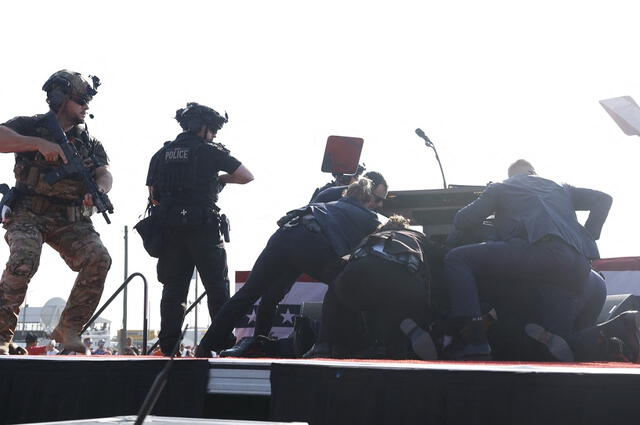 Los efectivos de seguridad en del lugar escoltaron de manera inmediata al expresidente norteamericano. Foto: AFP. 