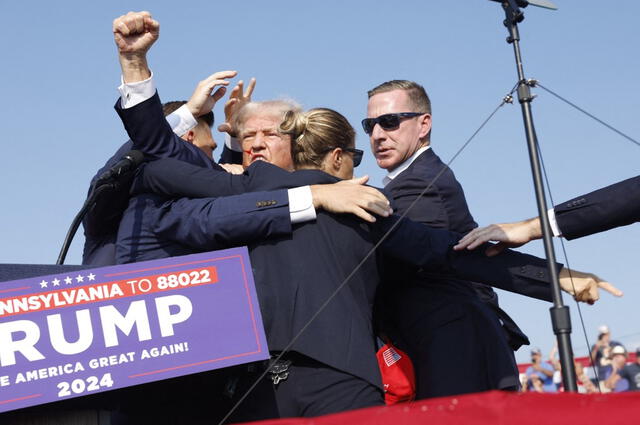 Trump dio señales de fortaleza a pesar de las manchas de sangre en su rostro provenientes de una posible herida en la oreja derecha. Foto: AFP.    