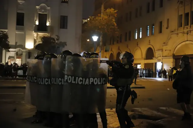 La represión continuó. Efectivo policial es captado con arma alzada apuntando a su objetivo a disparar. Ello ocurrió en la Plaza de Armas de Lima. Foto: Sebastián Blanco/URPI-LR La represión continuó. Efectivo policial es captado con arma alzada apuntando a su objetivo a disparar. Ello ocurrió en la Plaza de Armas de Lima. Foto: Sebastián Blanco/URPI-LR