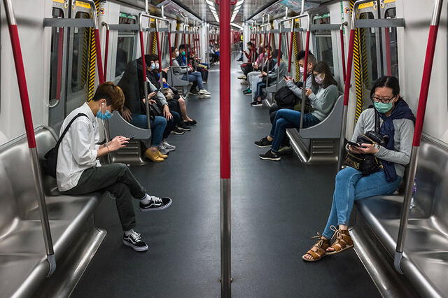 Las personas usan máscaras faciales y mantienen distancia social, en medio de preocupaciones por el coronavirus Covid-19, en un transporte público en Hong Kong.