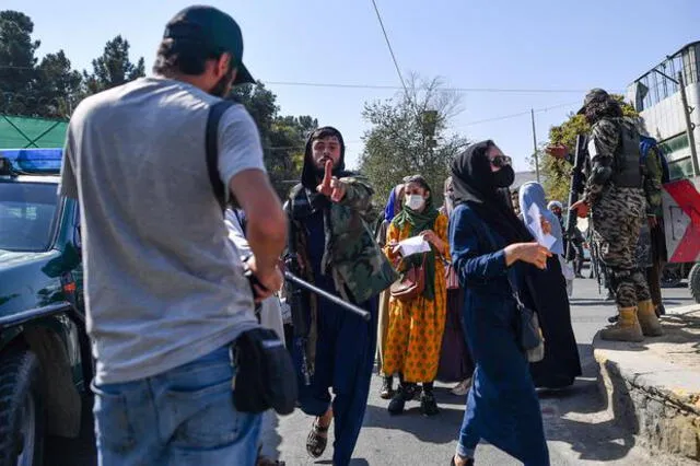 Miembro del Talibán amenazando a un reportero durante la manifestación. Foto: AFP