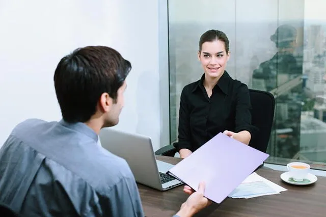 Durante una entrevista de trabajo, es importante entregar tu CV y prepararse para las preguntas del empleador. Foto: Questionpro   