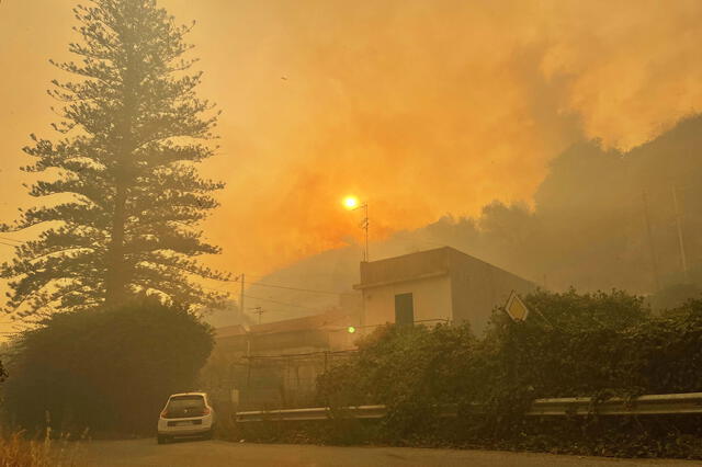 Casas en el distrito de Tono de Messina, Sicilia, rodeadas por el humo de los incendios en Italia. Foto: AFP   