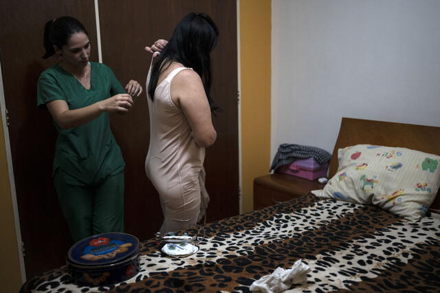 María convive con dos bolsas de drenaje colgados por su cintura. Foto: AFP