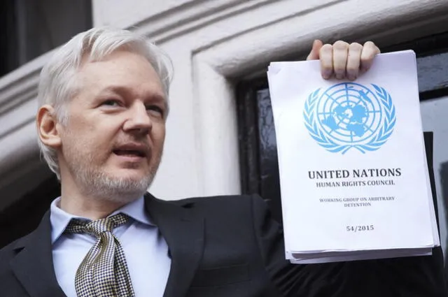 Assange sostiene un informe impreso de la sentencia del Grupo de Trabajo de la ONU sobre Detenciones Arbitrarias sobre su caso desde el balcón de la embajada de Ecuador. Foto: AFP   