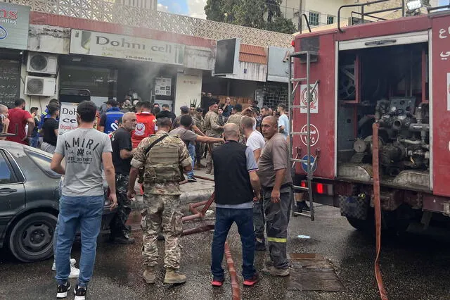 Varias personas y equipos de primeros auxilios se reúnen en el lugar de la explosión de un artefacto en Saida, en el sur del Líbano. Foto: AFP   