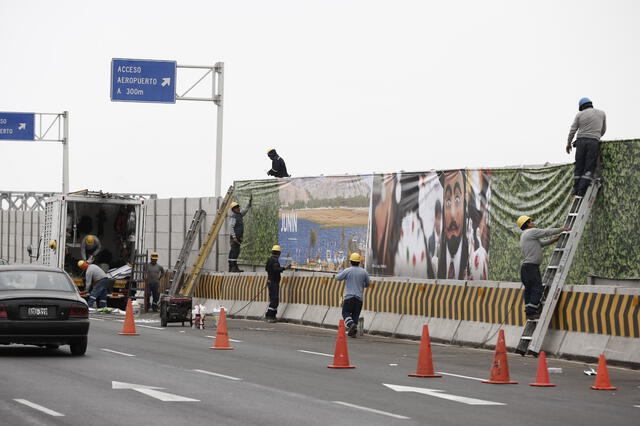 . Maquillaje. Obreros de la Municipalidad del Callao colocan gigantografías a un lado de la vía. No hay policías en la zona. Foto: Marco Cotrina . Maquillaje. Obreros de la Municipalidad del Callao colocan gigantografías a un lado de la vía. No hay policías en la zona. Foto: Marco Cotrina
