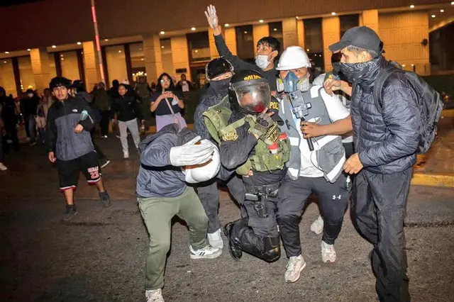 Samuel, quien viste una casaca azul, buzo verde y un casco blanco, ayudó a un efectivo policial en medio de las manifestaciones. Foto: Stifs Paucca/El Megáfono   