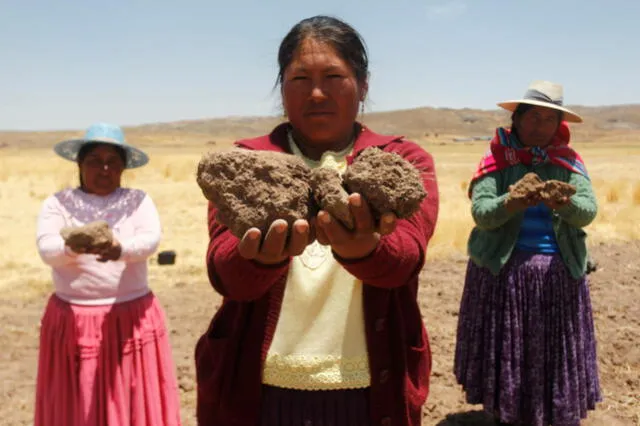 Mujer sujeta en sus manos la  tierra árida por falta de lluvias, en la comunidad Buena Vista, Atuncolla