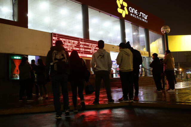 Un grupo de jóvenes esperan en los exteriores del local de Los Próceres (SJL) para hacer la cola. Foto: John Reyes