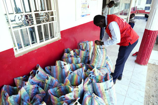 Un miembro de la Cruz Roja de Gambia revisa sacos de jarabes para la tos recolectados en Banjul, tras la muerte de 66 niños. Foto: AFP
