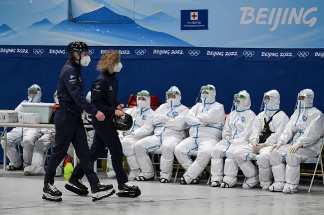 El personal que usa equipo de protección personal (EPP) se sienta en una estación médica antes de un partido de hockey sobre hielo de los Juegos Olímpicos de Invierno de Beijing 2022 entre Canadá y Suiza. Foto: AFP