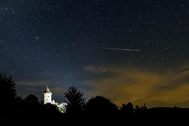 Una estrella fugaz cruza el cielo sobre el castillo de Somosko visto desde Salgotarjan, Hungría. Foto: EFE