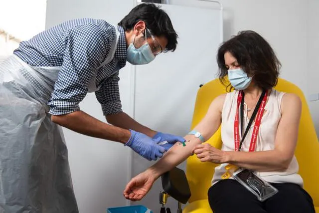 Uno de los miembros del equipo tomando muestra de sangre de uno de los voluntarios de la vacuna. (Foto: Bloomberg)
