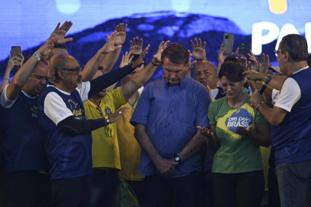 El ministro evangélico Silas Malafaia y otros líderes evangélicos oran alrededor del presidente brasileño Jair Bolsonaro y la primera dama Michelle Bolsonaro. Foto: AFP