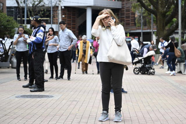 Una mujer habla por su teléfono mientras permanece en la calle tras un terremoto en Bogotá, el 17 de agosto de 2023. Foto: AFP   