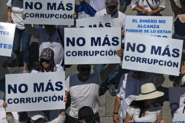  Carteles de “No más corrupción” durante una protesta contra las políticas del presidente Nayib Bukele y su reelección. Foto: AFP    