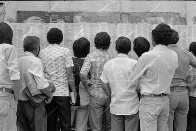 9 de abril de 1980. Postulantes a San Marcos leen las relaciones de ingresantes pegadas en la pared de un colegio donde rindieron la prueba. Foto: José Risco/El Peruano   