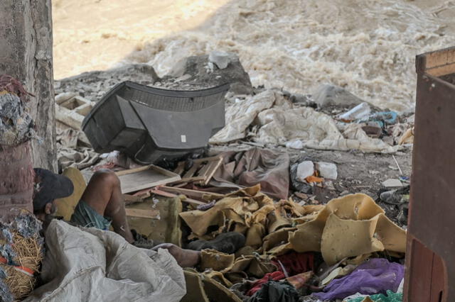 Ambulante junto a los desperdicios debajo del Puente Río Chillón, en Comas. Foto: Miguel Vásquez.   