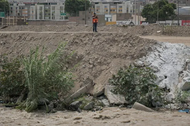 Personal de Defensa Civil supervisando el caudal del río Chillón en el Puente Tambo Río, en Puente Piedra. Foto: Miguel Vásquez.   