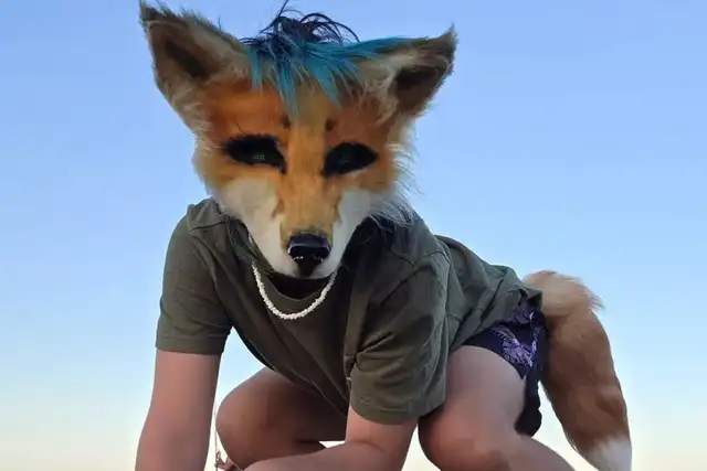 Persona con orejas y cola de zorro, mostrando su conexión profunda con esta especie como parte de su identidad therian.   