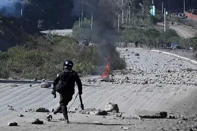 Agentes antidisturbios retiran piedras de una carretera bloqueada por manifestantes rurales en Lipari, departamento de La Paz
