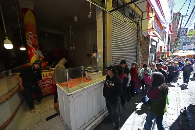 La gente hace fila para comprar carne de pollo en un mercado que sufría escasez debido a los conflictos y los bloqueos de carreteras