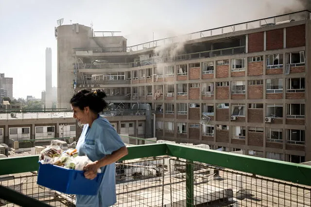A nurse carries medical supplies past smoke-filled buildings at Soroka Hospital after an Iranian missile strike in Beersheba, southern Israel. Photo: AFP A nurse carries medical supplies past smoke-filled buildings at Soroka Hospital after an Iranian missile strike in Beersheba, southern Israel. Photo: AFP