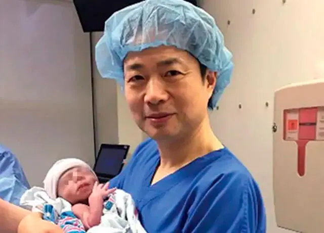 John Zhang con el bebé en sus brazos. Foto: New Scientist